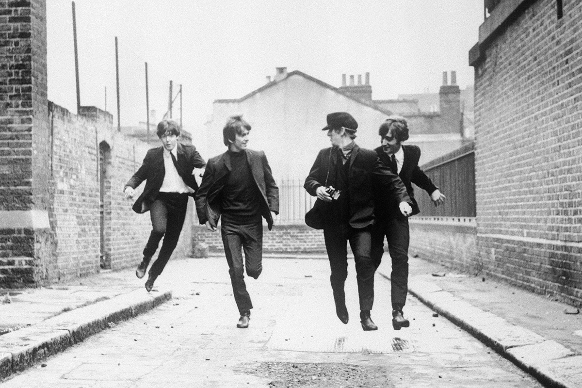 From left to right, Paul McCartney, George Harrison, John Lennon, and Ringo Starr run down an empty London street in a scene from the movie A Hard Day's Night, 1964.
