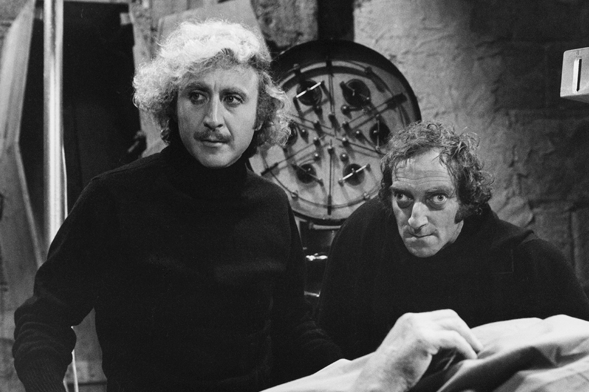 Gene Wilder and Marty Feldman standing over body in a scene from the film 'Young Frankenstein', 1974. (Photo by 20th Century-Fox/Getty Images)
