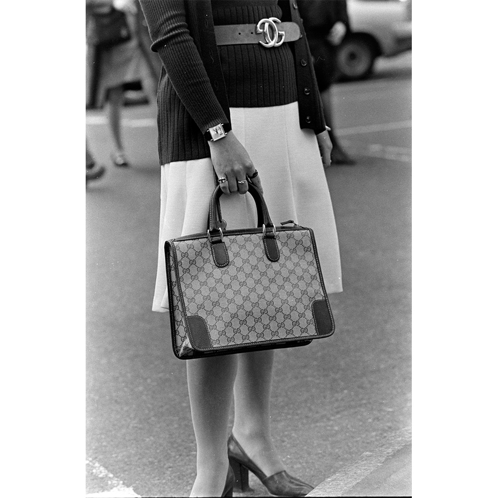 A model shows off a Gucci GG Canvas handbag with leather trim and leather belt with an interlocking GG buckle from the House of Gucci spring 1974 handbag collection.