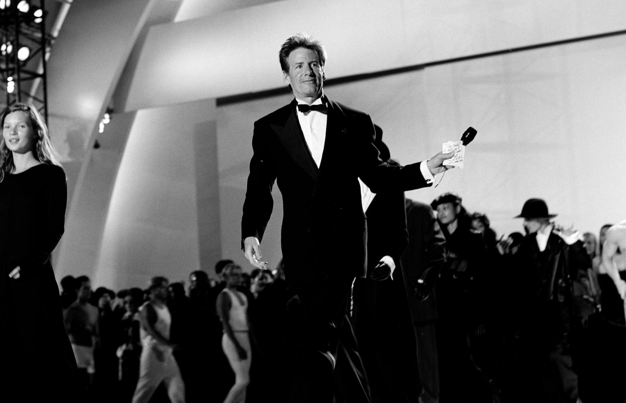 Kate Moss (L) and Calvin Klein (C)  onstage during the AIDS Project LA mega-gala at the Hollywood Bowl on June 4, 1993.