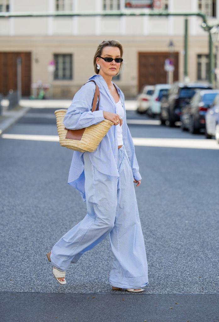 BERLIN, GERMANY - MAY 01: Tina Haase is seen wearing Arket blue striped button shirt and pyjama pants, Y Project white ribbed tanktop, beige Loewe Basket Bag, Celine Sunglasses on May 01, 2024 in Berlin, Germany.  (Photo by Christian Vierig/Getty Images)
