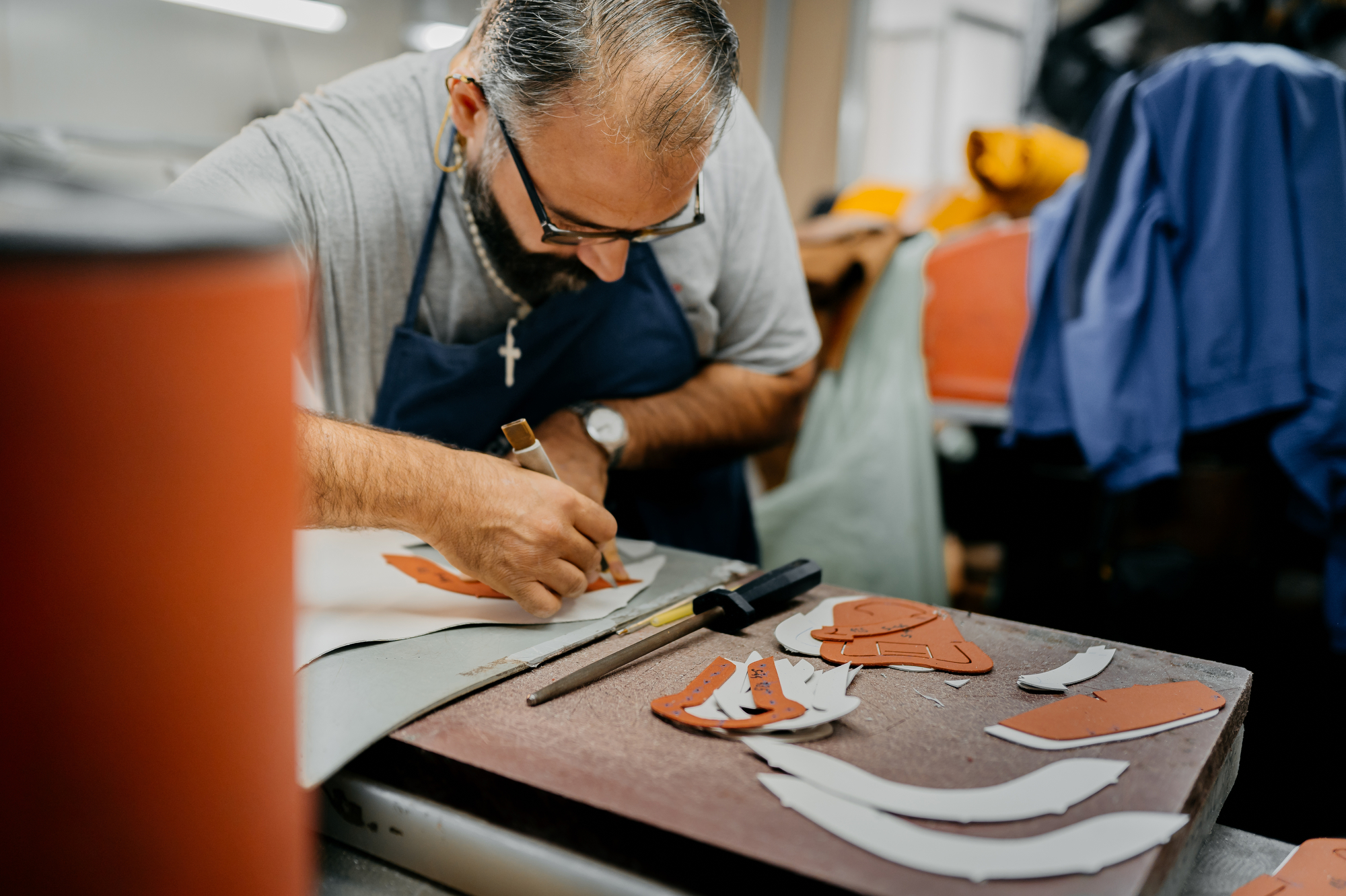 An artisan prepares leather to make shoes.