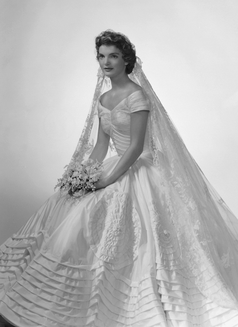 Bridal portrait of Jacqueline Lee Bouvier (1929 - 1994) shows her in an Anne Lowe-designed wedding dress, a bouquet of flowers in her hands, New York, New York, 1953. (Photo by Bachrach/Getty Images)