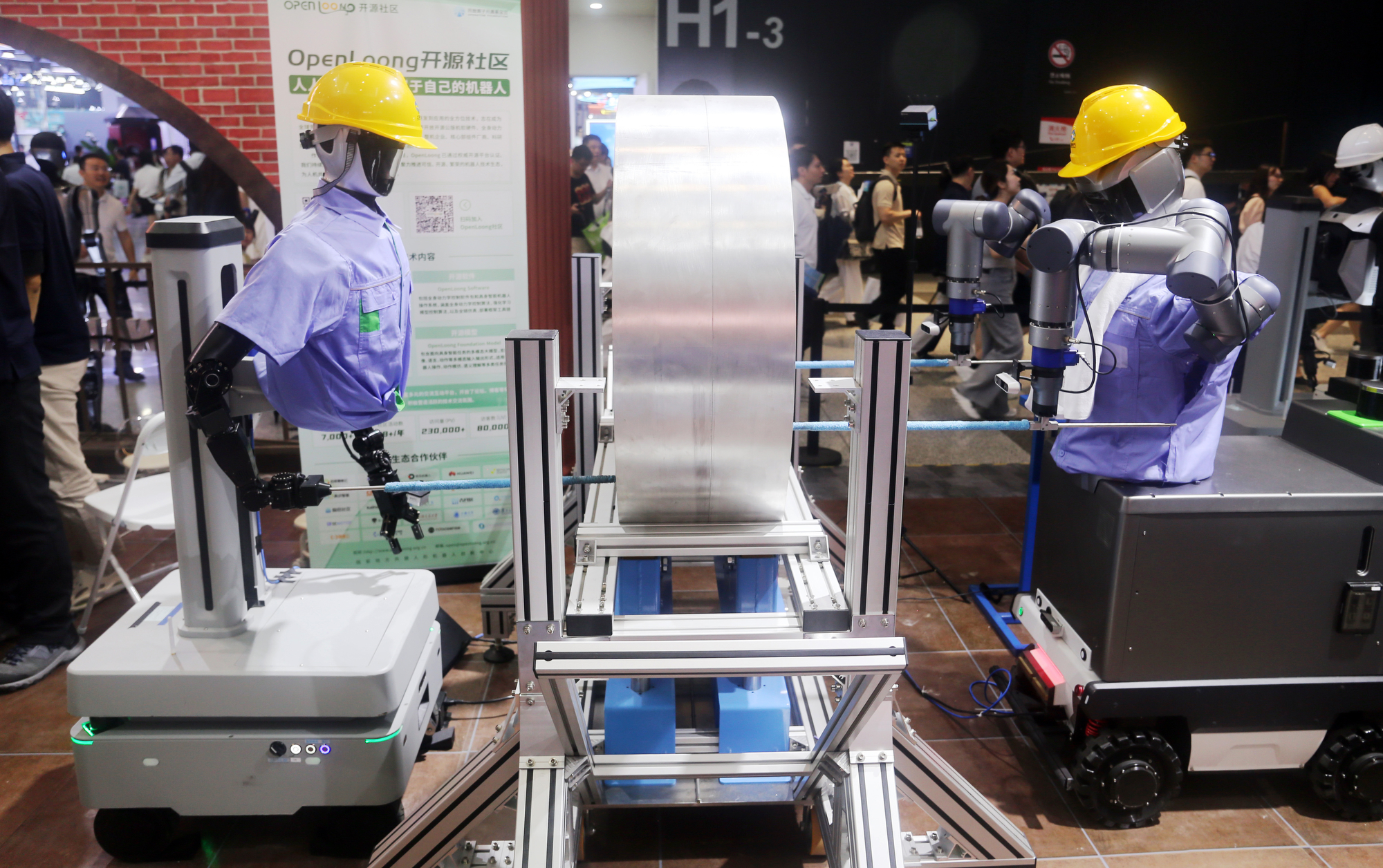 Robots wearing work clothes demonstrate working in factory workshop scenarios at the 2025 WAIC World Artificial Intelligence Conference in Shanghai, China, on July 29, 2025.